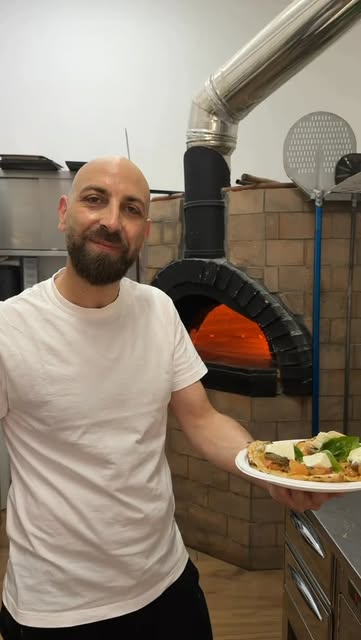 Il pizzaiolo di Regina Margherita accanto al forno a legna
